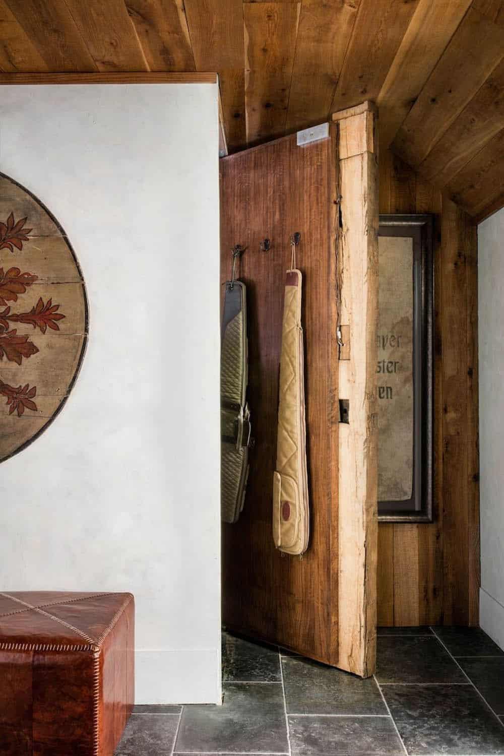 Rustic mudroom entry with reclaimed wood ceiling, live-edge door frame, and wall hooks