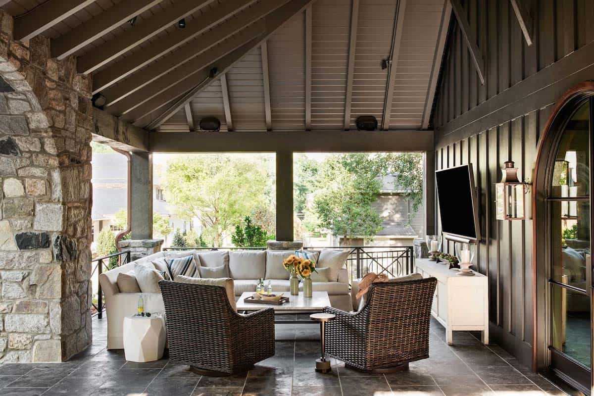 Covered pool house porch with vaulted ceiling, wicker sectional seating, and outdoor television