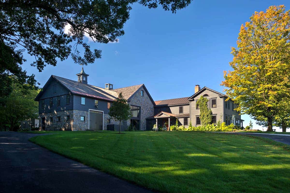 Aerial view of restored 18th century farmhouse complex with barn, stone addition, and sweeping green lawns