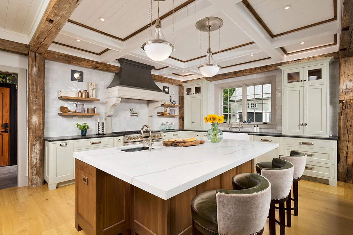 Farmhouse kitchen with sage green cabinetry, walnut island, white marble countertop, coffered ceiling, and reclaimed beams