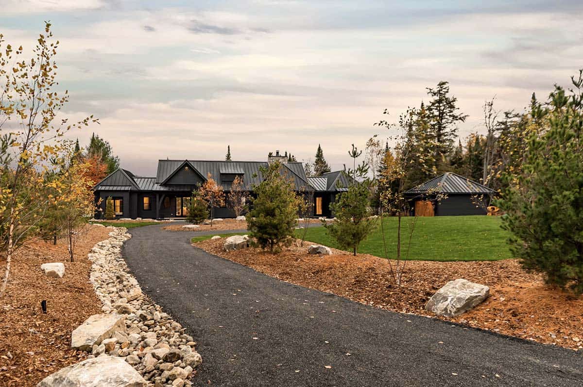 Top-down aerial showcasing complex multi-gable black metal roof geometry of cottage