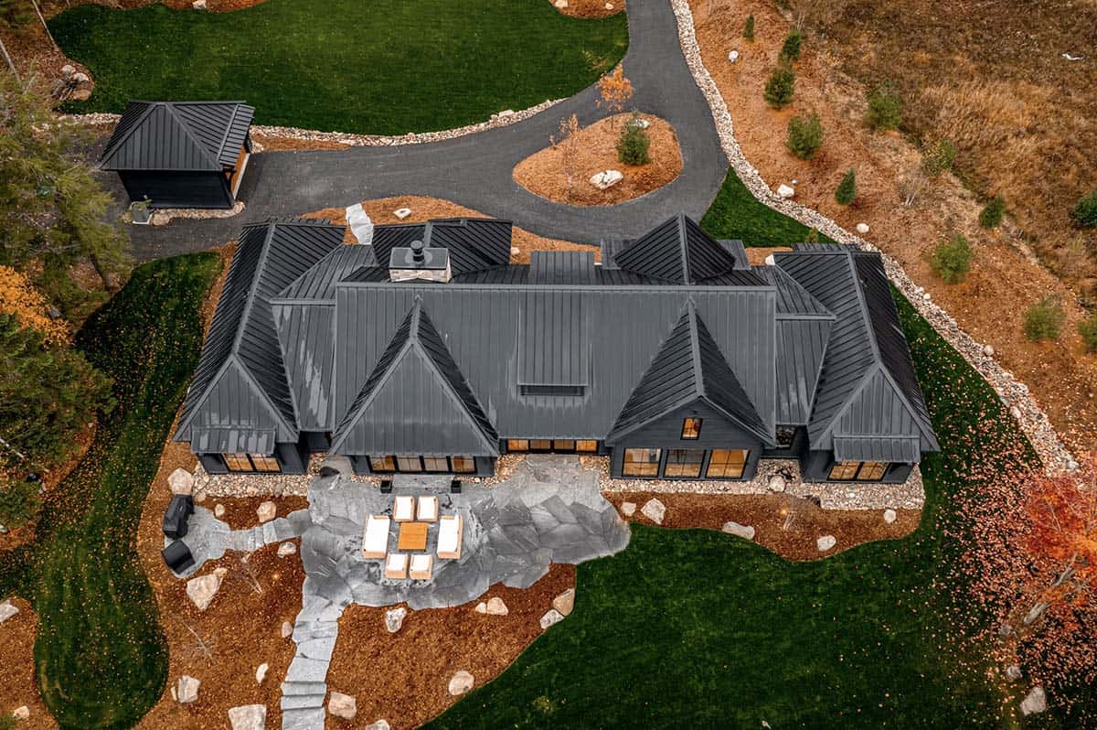 Aerial view of cottage rear with large slate patio seating area and circular driveway