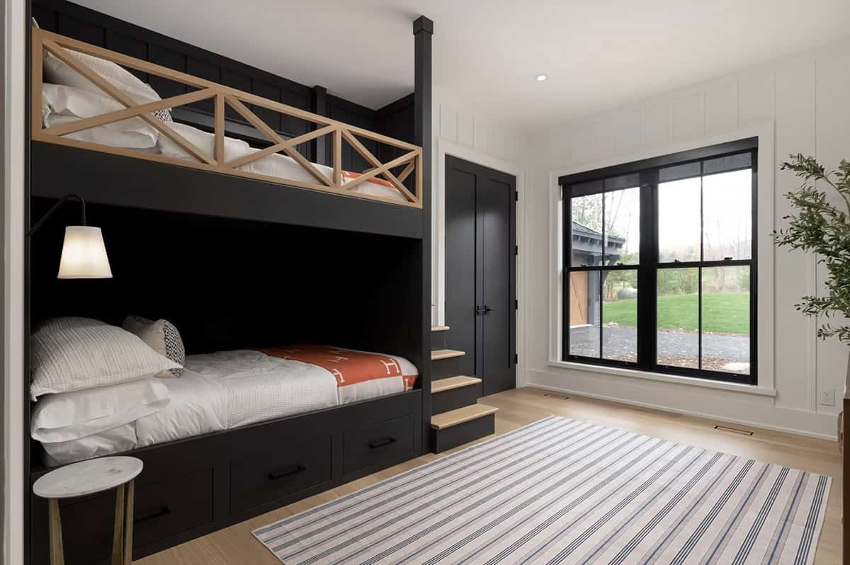 Kids bedroom with built-in dark bunk beds, wood X-railing, stair steps, under-bed drawers, and striped rug
