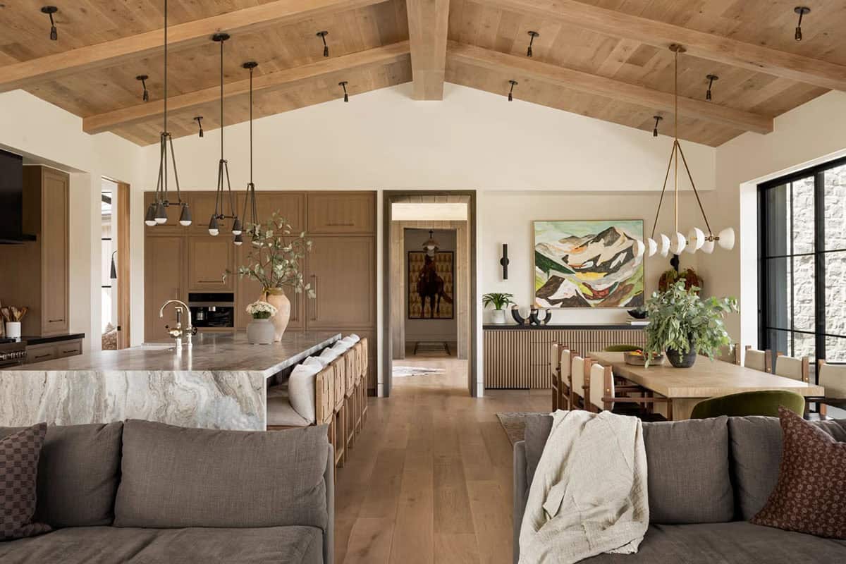 Open-plan kitchen and dining area with vaulted wood ceiling and large kitchen island