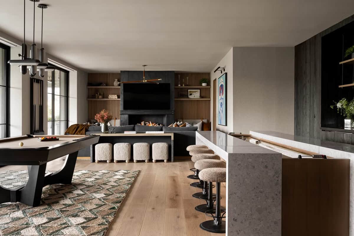 Lower-level game room with pool table, bar seating, and entertainment area