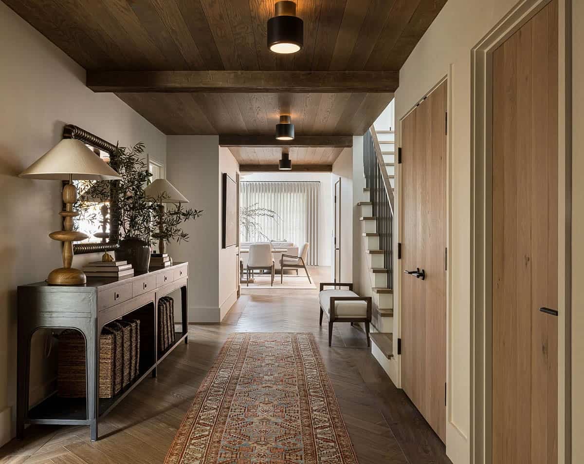 Entryway hallway with wood beam ceiling and herringbone floors