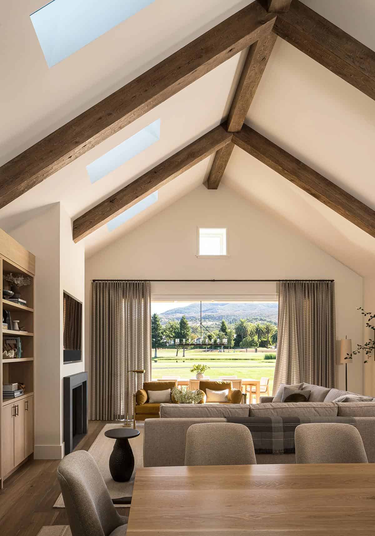 Vaulted living room with exposed wood beams and golf course views