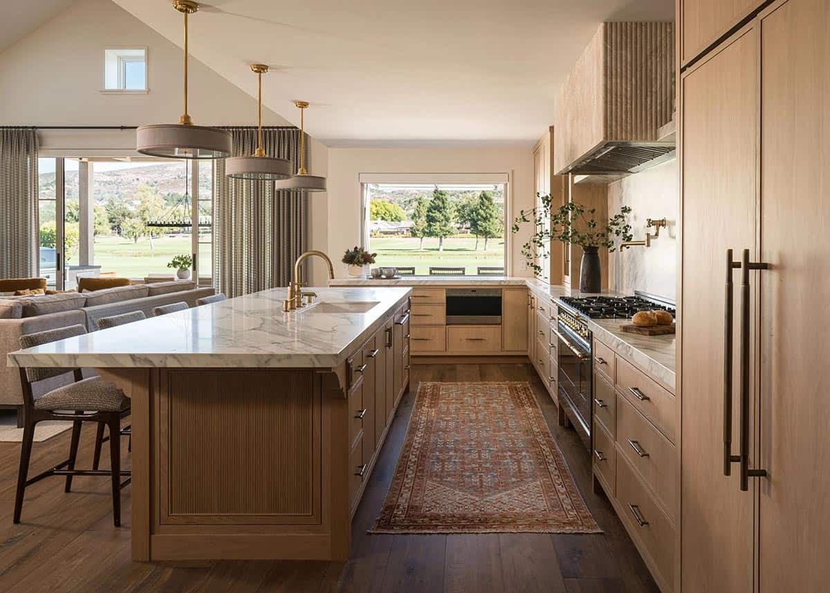 Kitchen island with golf course views and brass pendants