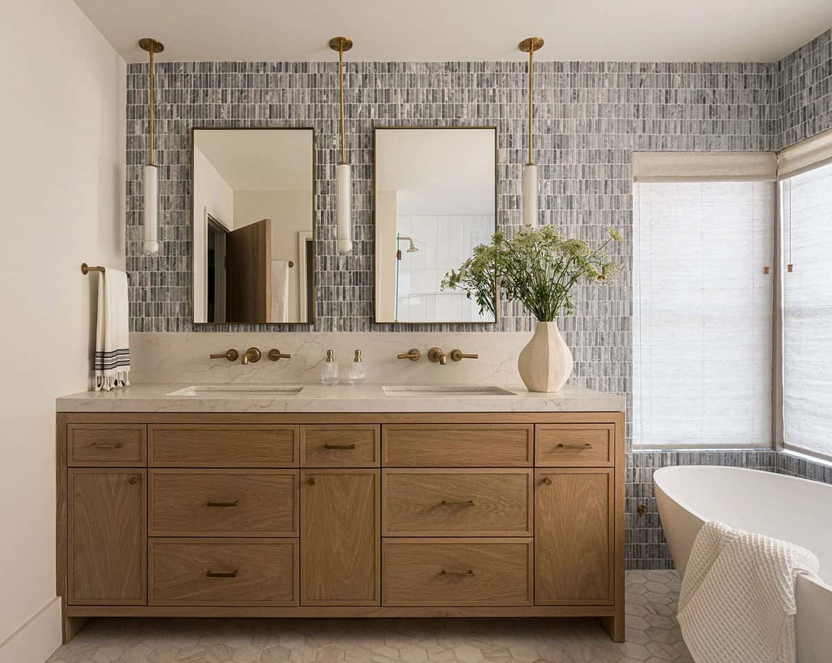 Primary bathroom with double vanity gray tile and freestanding tub