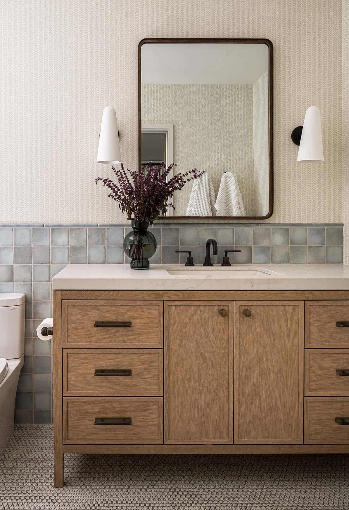 Bathroom vanity with blue tile backsplash penny tile floor and wood cabinet