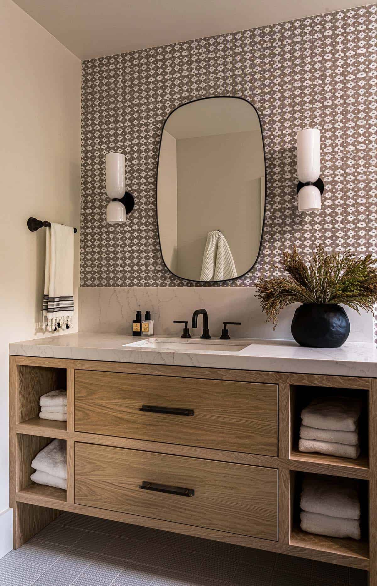 Guest bathroom with daisy wallpaper floating oak vanity and black mirror