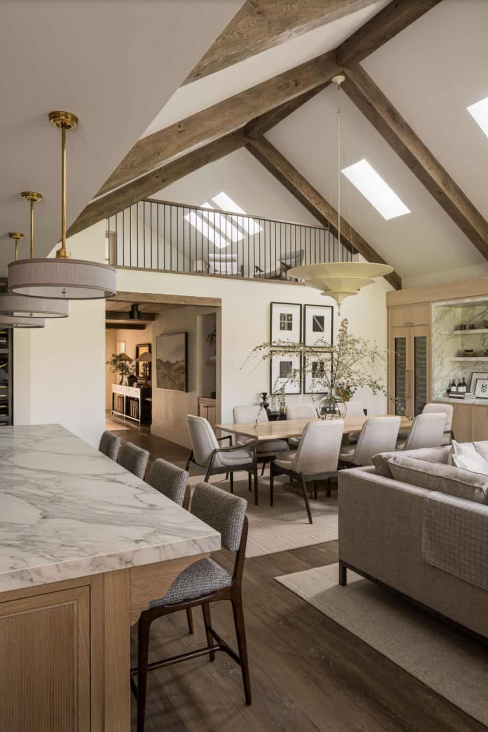 Open plan living dining and kitchen with vaulted ceiling and exposed wood beams