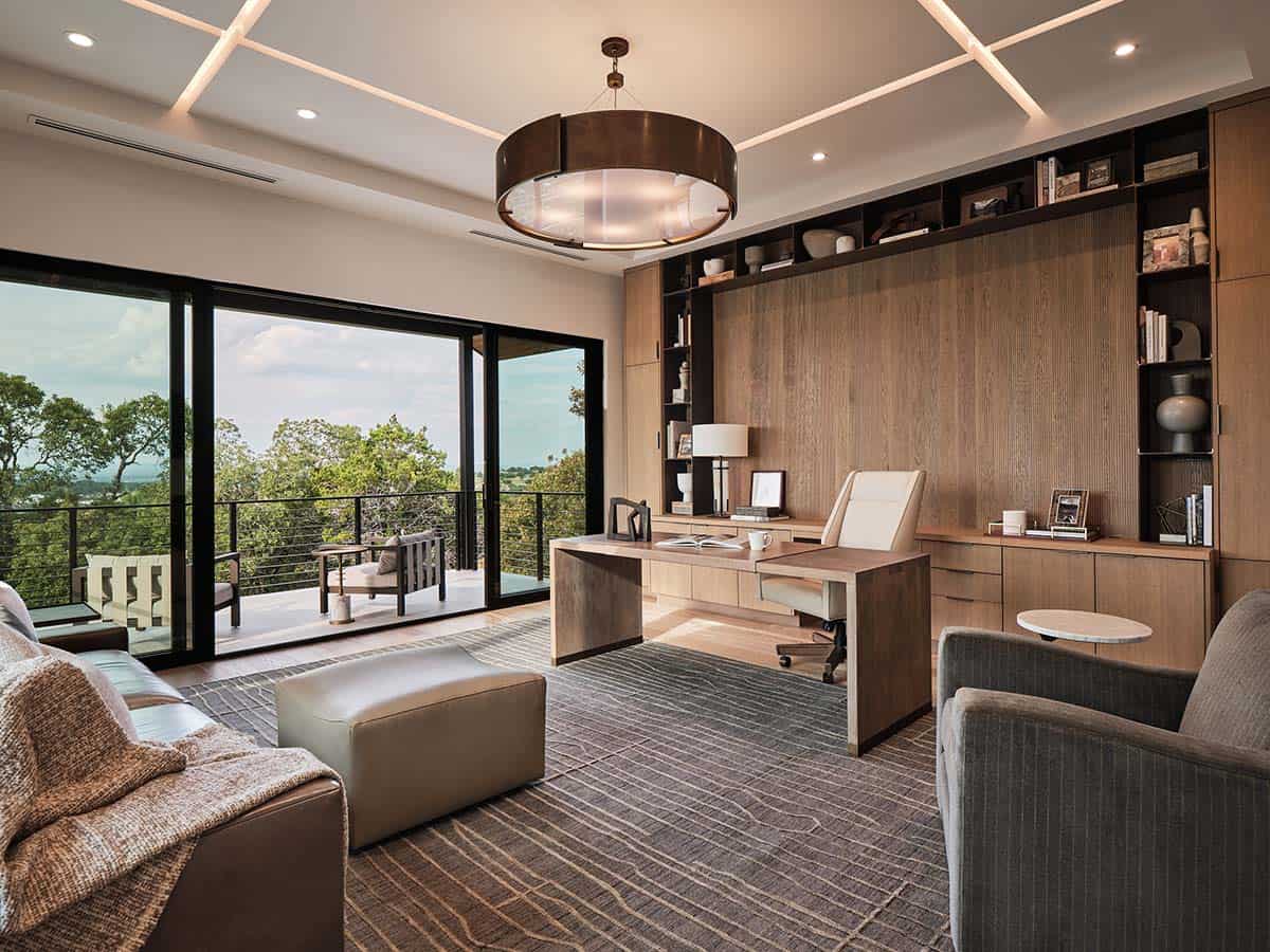 Home office with floor-to-ceiling oak built-ins, floating wood desk, bronze drum chandelier, and balcony views