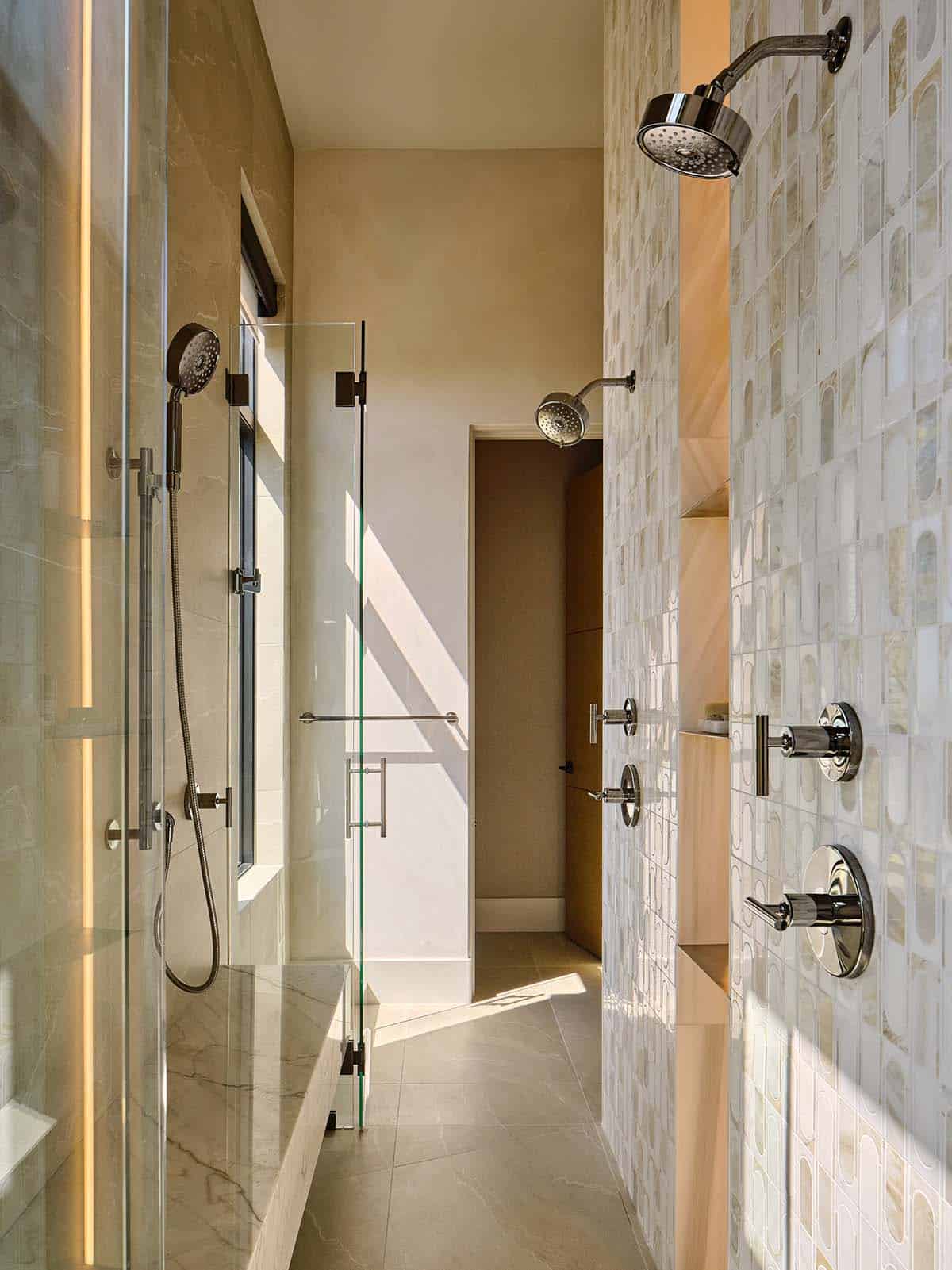 bathroom dual shower with mosaic tile wall, marble tile, and polished chrome fixtures