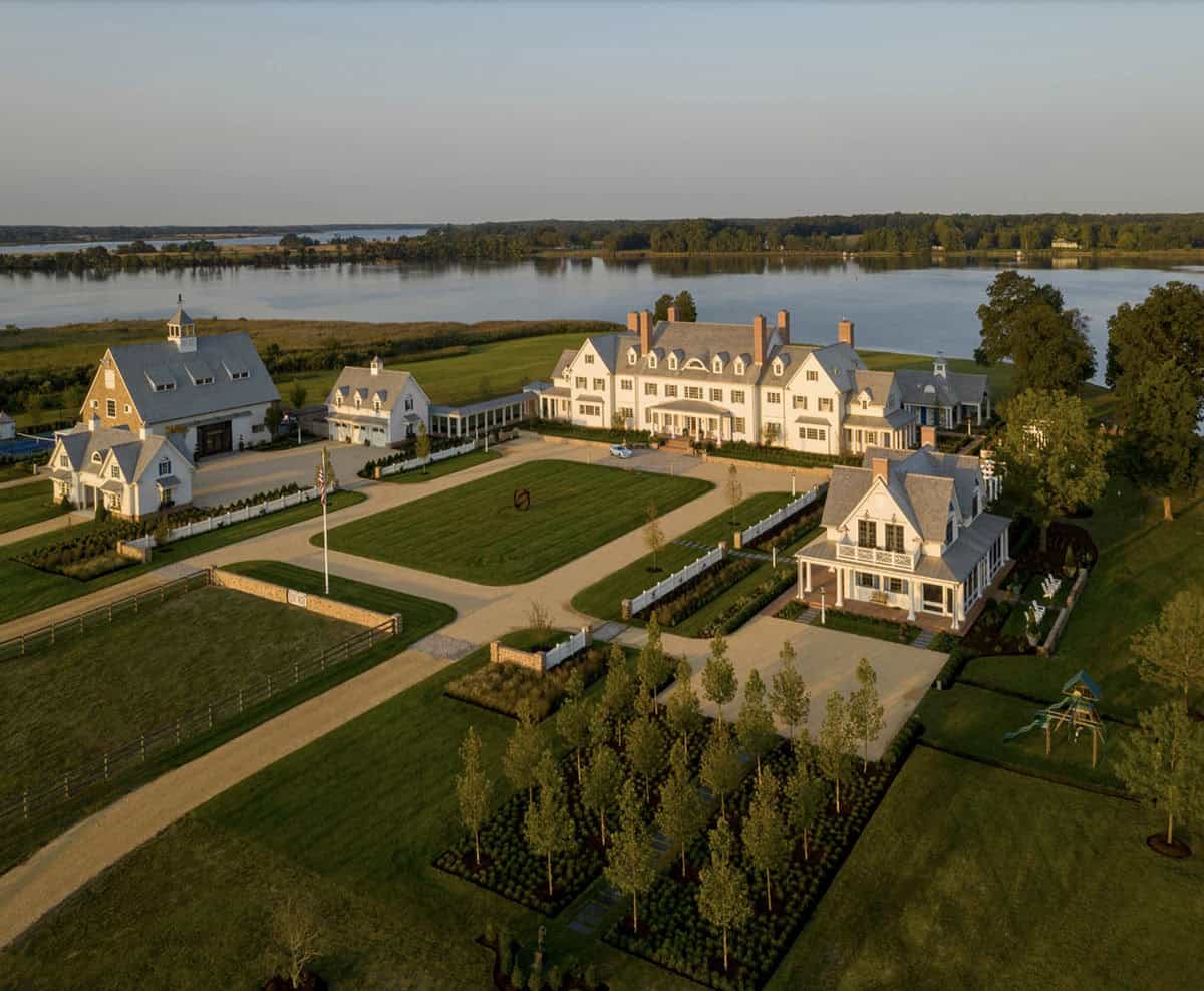 Aerial view of Maryland waterfront estate at golden hour showing main house, outbuildings, formal gardens, and children's play area