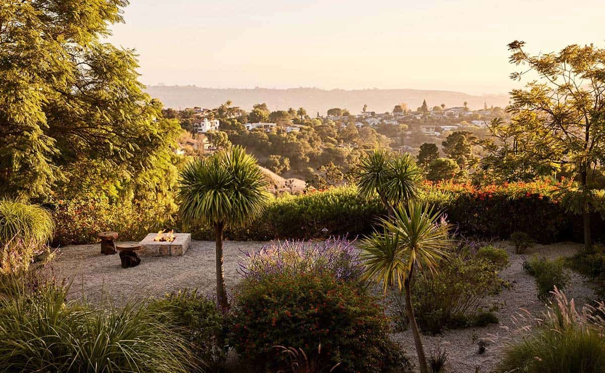 Garden fire pit area with yucca trees, lavender, and sweeping hillside city views at golden hour