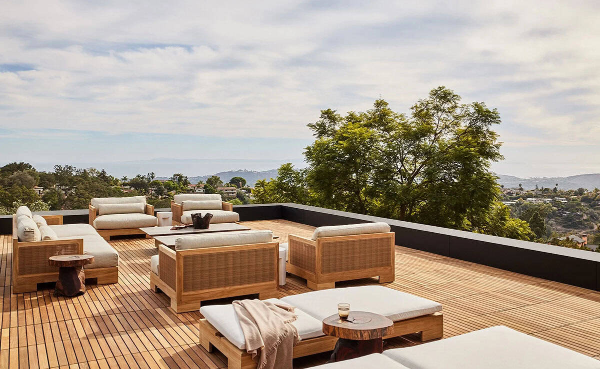 Rooftop deck with teak lounge furniture, sun loungers, and sweeping panoramic California hillside views