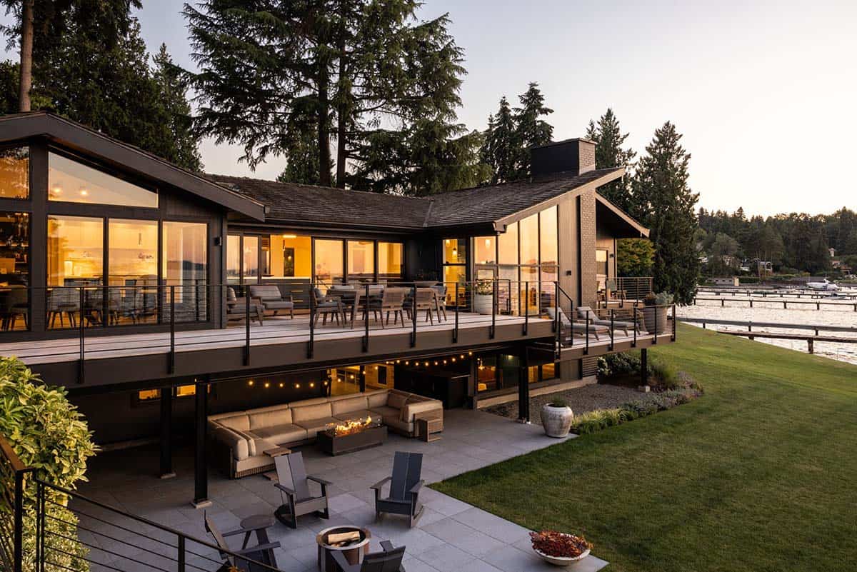 Mid-century modern lakefront home at dusk with two-level deck, fire pit patio, and lake views on Mercer Island