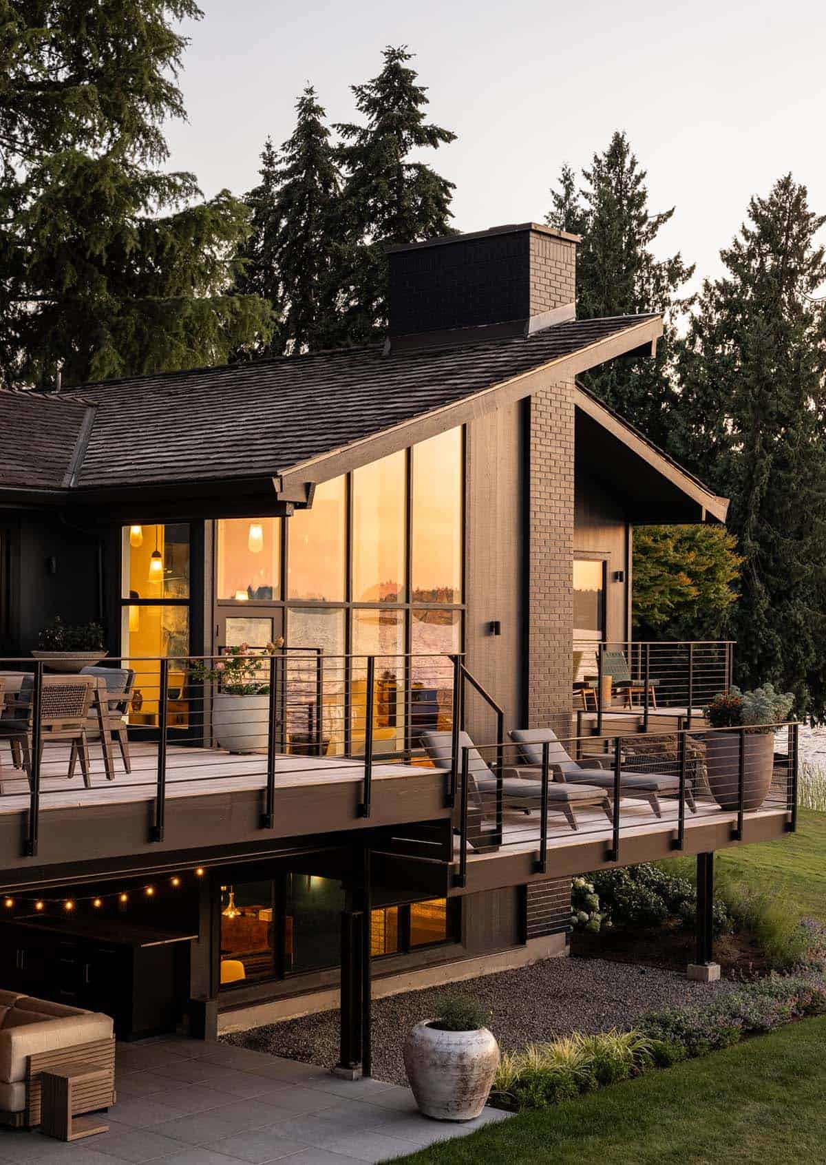 Mid-century modern home at sunset with wraparound deck, cable railing, and waterfront views on Mercer Island