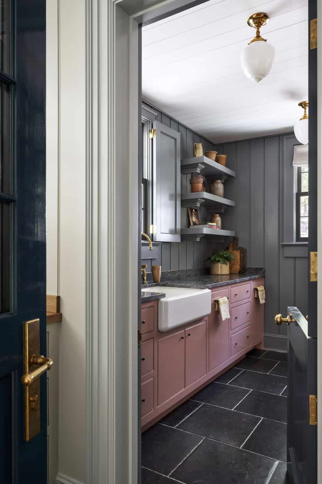 Scullery with dusty rose cabinets, slate floor, farmhouse sink, and gray beadboard walls