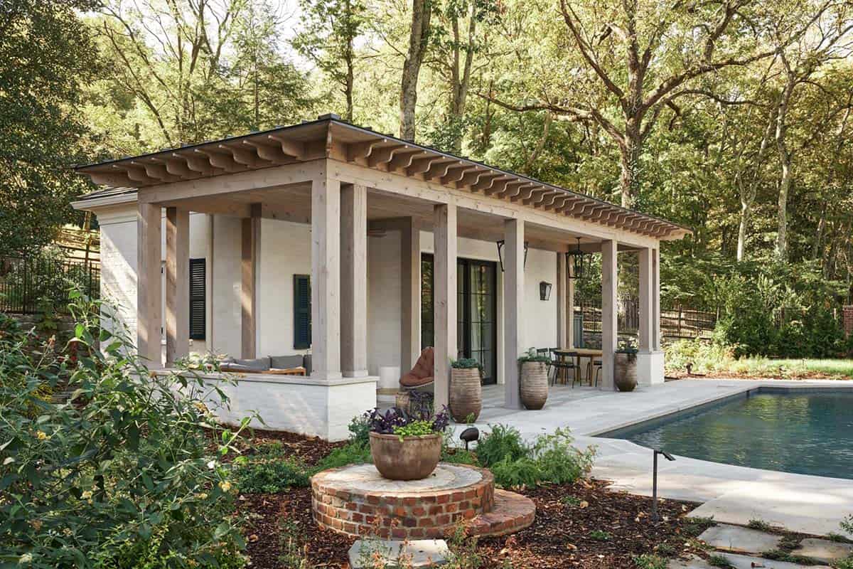 Rustic pool cabana with weathered wood columns, scalloped rafter tails, and poolside outdoor dining