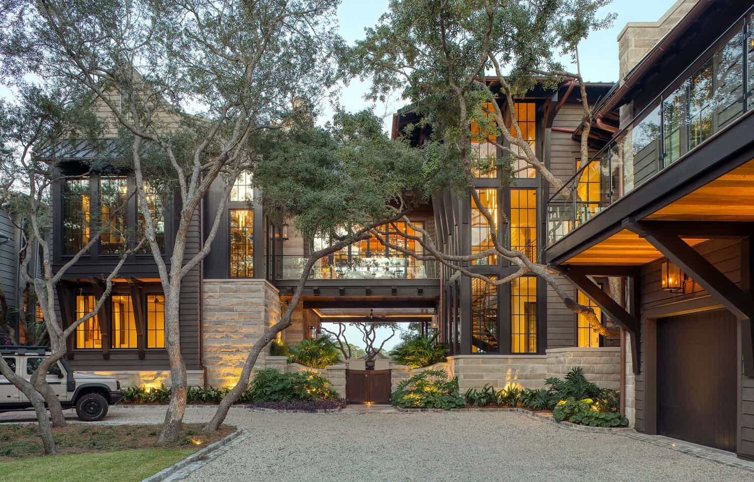 Modern luxury lake house exterior with stone and wood siding at dusk