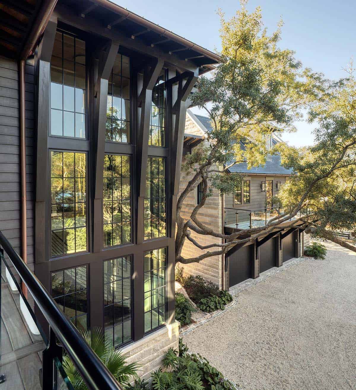 Multi story lake house exterior with floor to ceiling steel frame windows