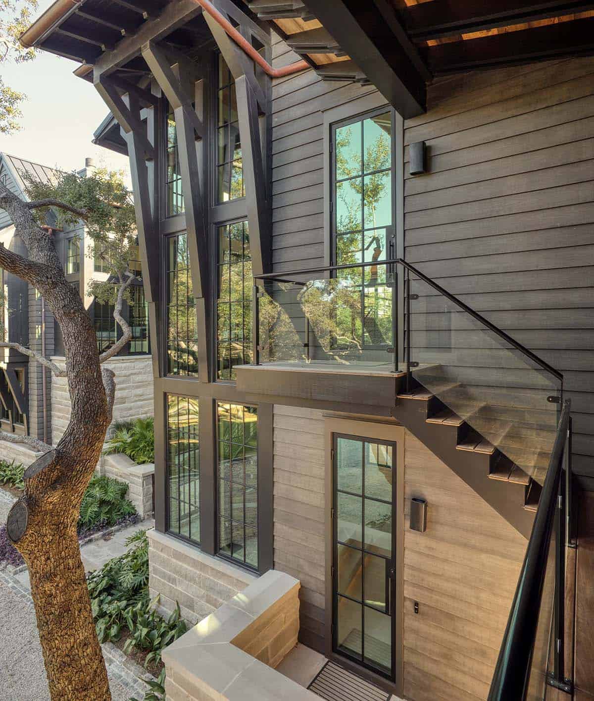 Lake house exterior staircase with steel frame windows and stone cladding