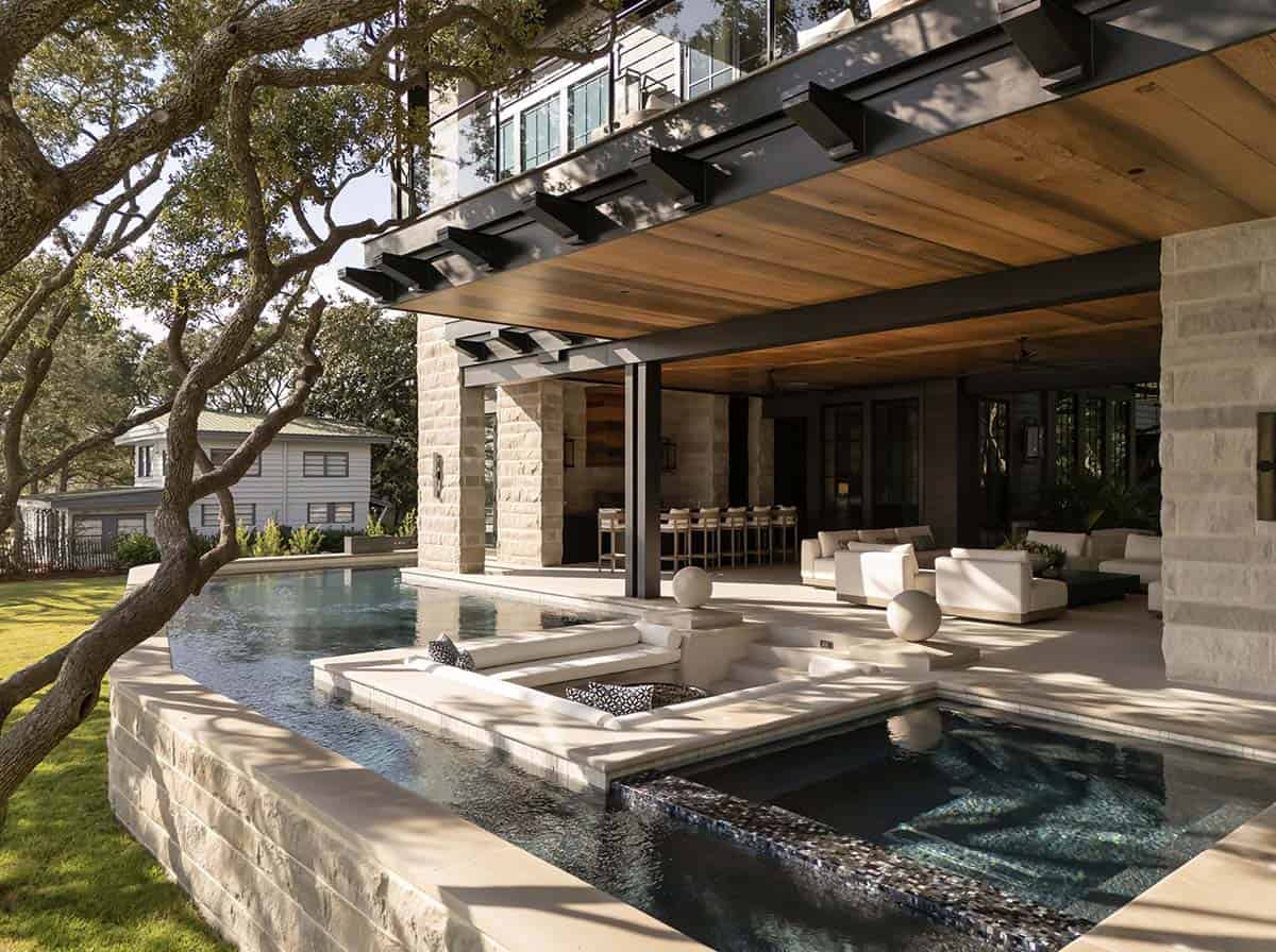 Luxury pool with in pool seating covered outdoor living area and lake views