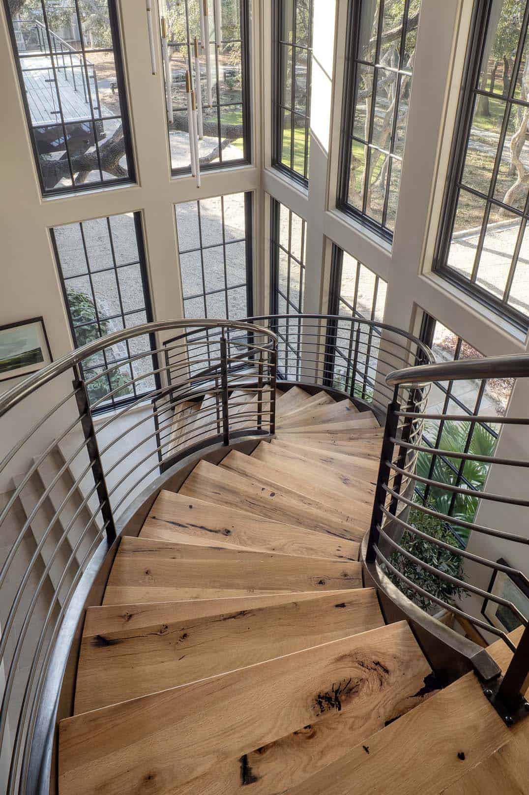 Curved spiral staircase with oak treads steel railing and floor to ceiling windows