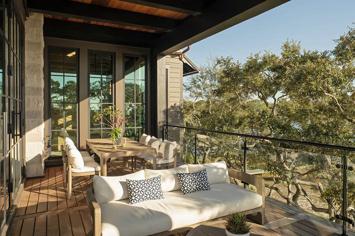 Upper deck with teak dining set and lake views through mature oak trees