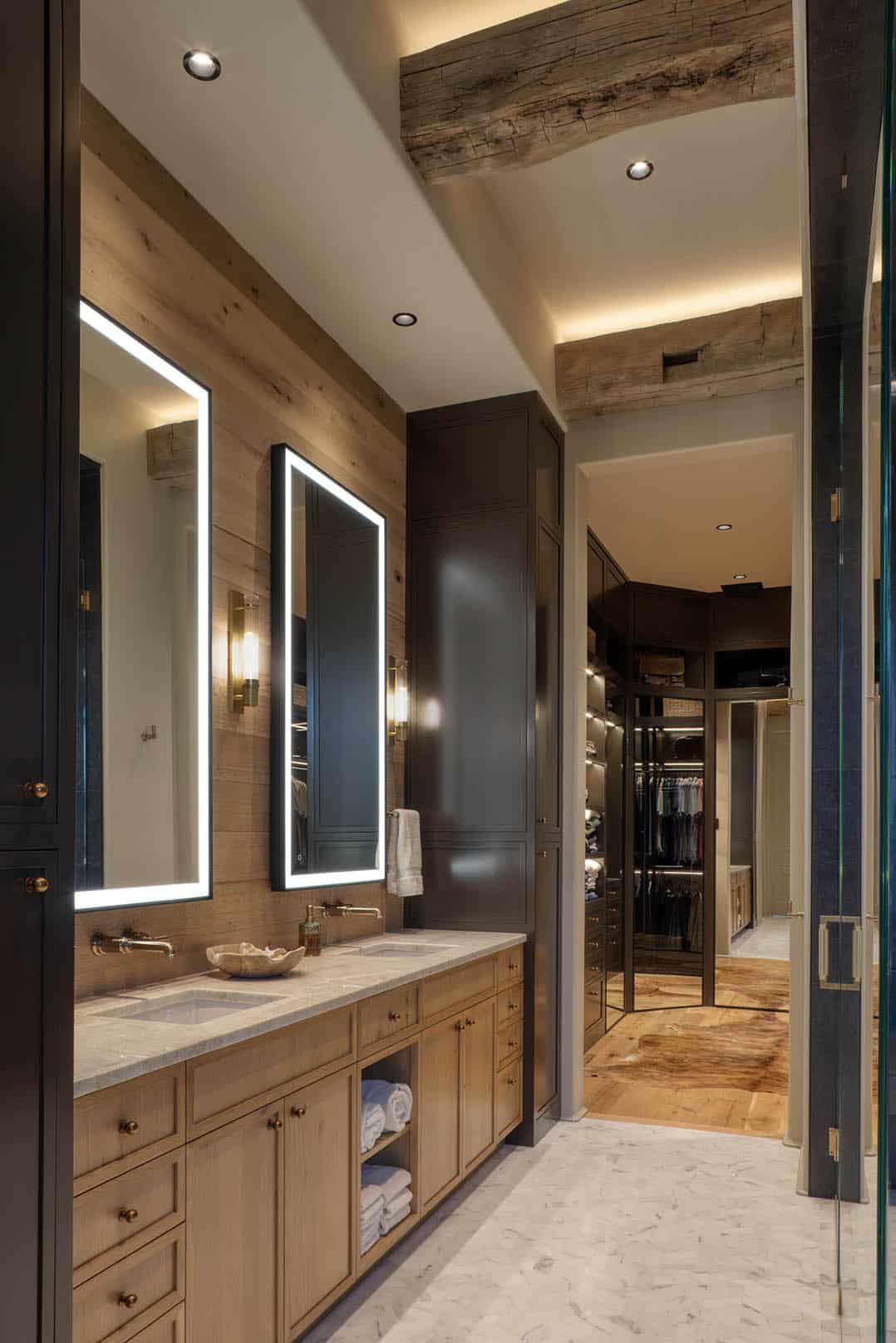 Primary bathroom with double oak vanity LED mirrors and walk-in closet
