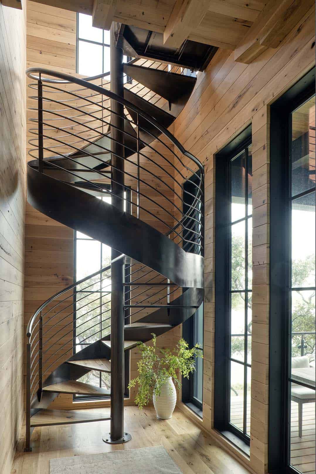 Black spiral staircase with wood treads and steel frame windows
