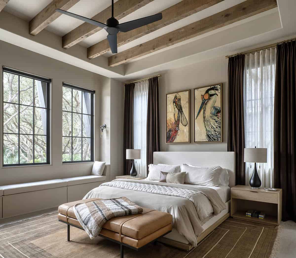 Guest bedroom with wood beam ceiling bird artwork and leather bench