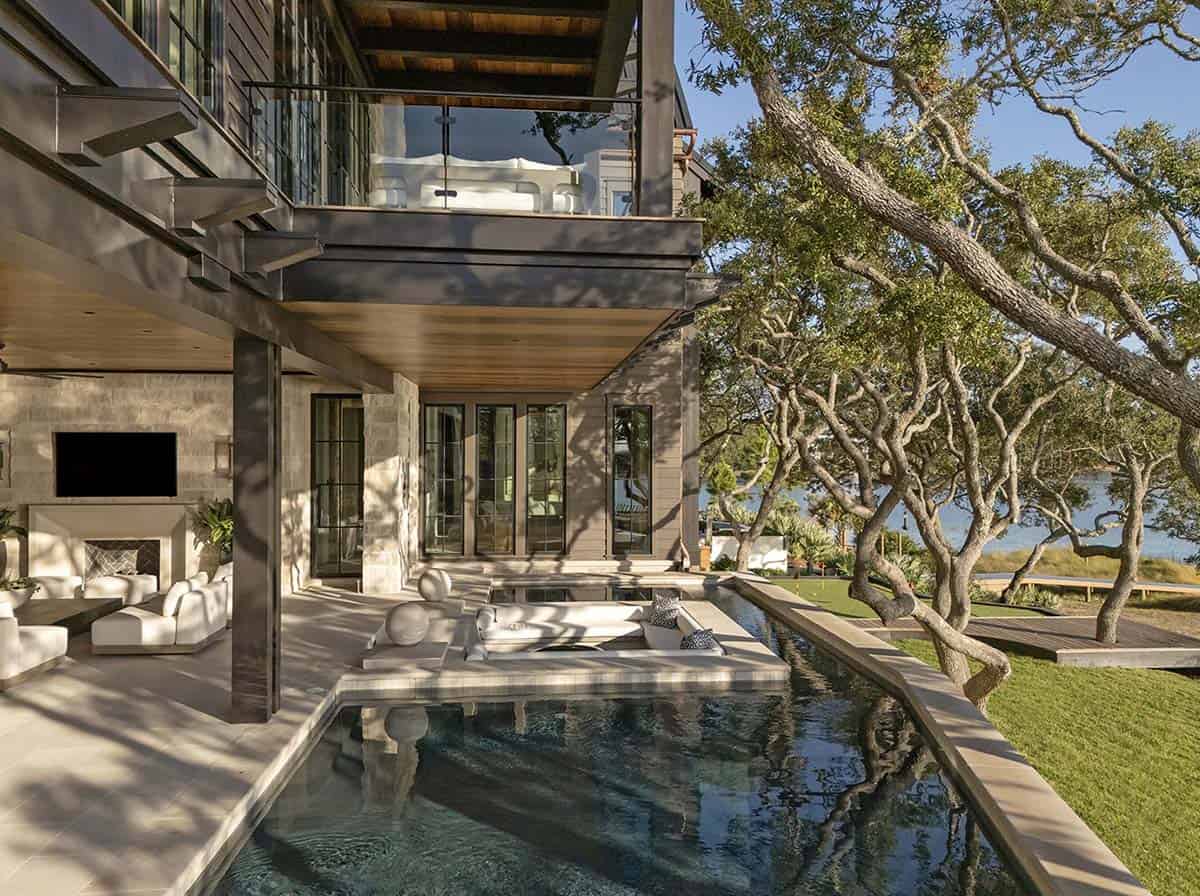 Lake house rear exterior with pool putting green and covered outdoor living area