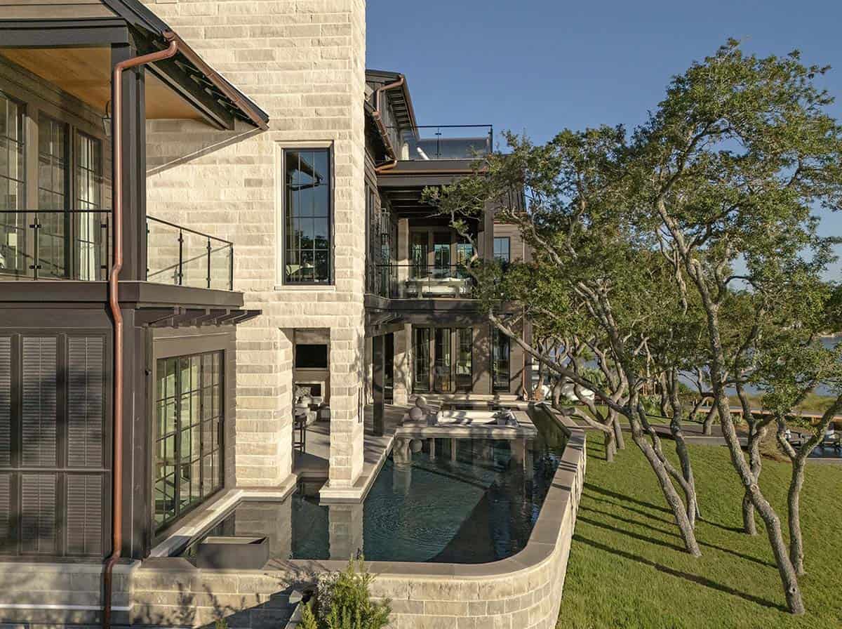 Lake house side exterior with lap pool copper gutters and stone cladding