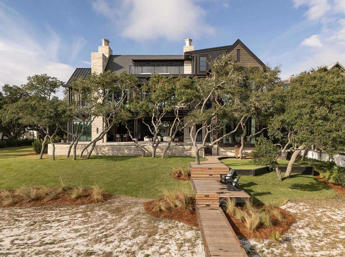 Lake house rear exterior with boardwalk putting green and oak tree canopy