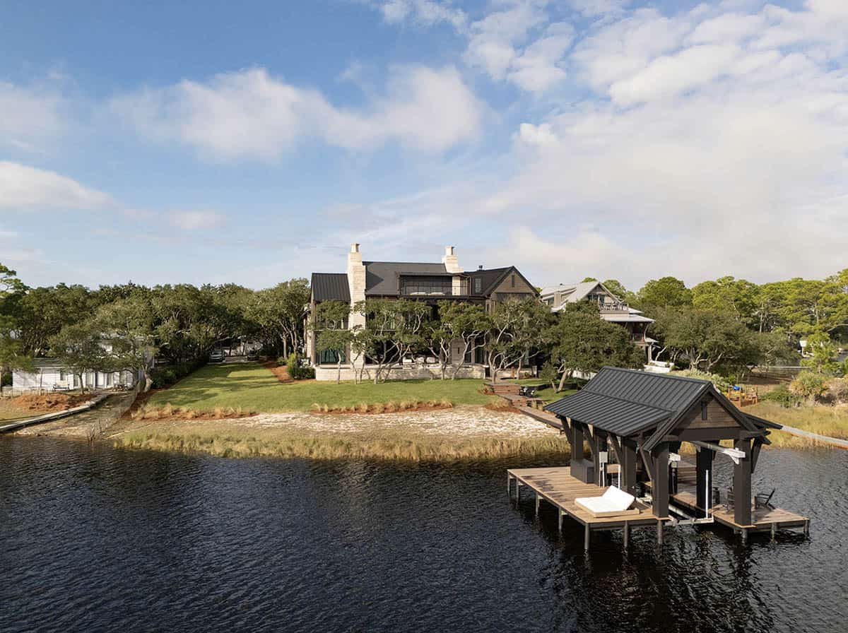 Aerial view of lake house with covered dock and waterfront setting