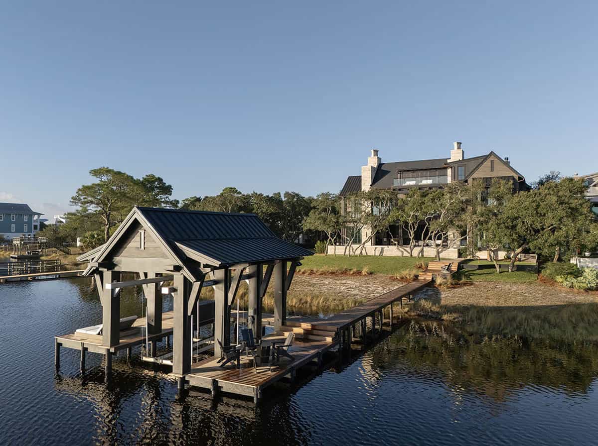 Covered dock with wood walkway and lake house view at golden hour