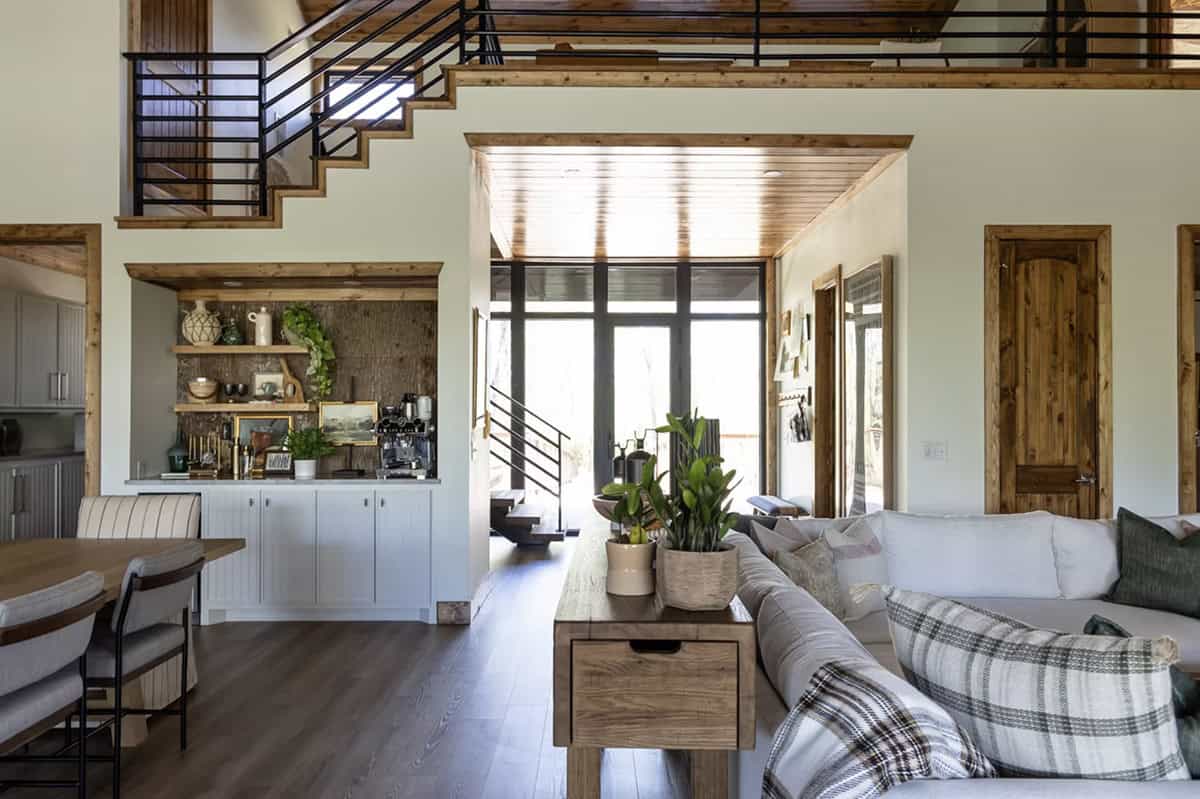 Living room with white sofas, built-in coffee bar niche, and view to bridge entry