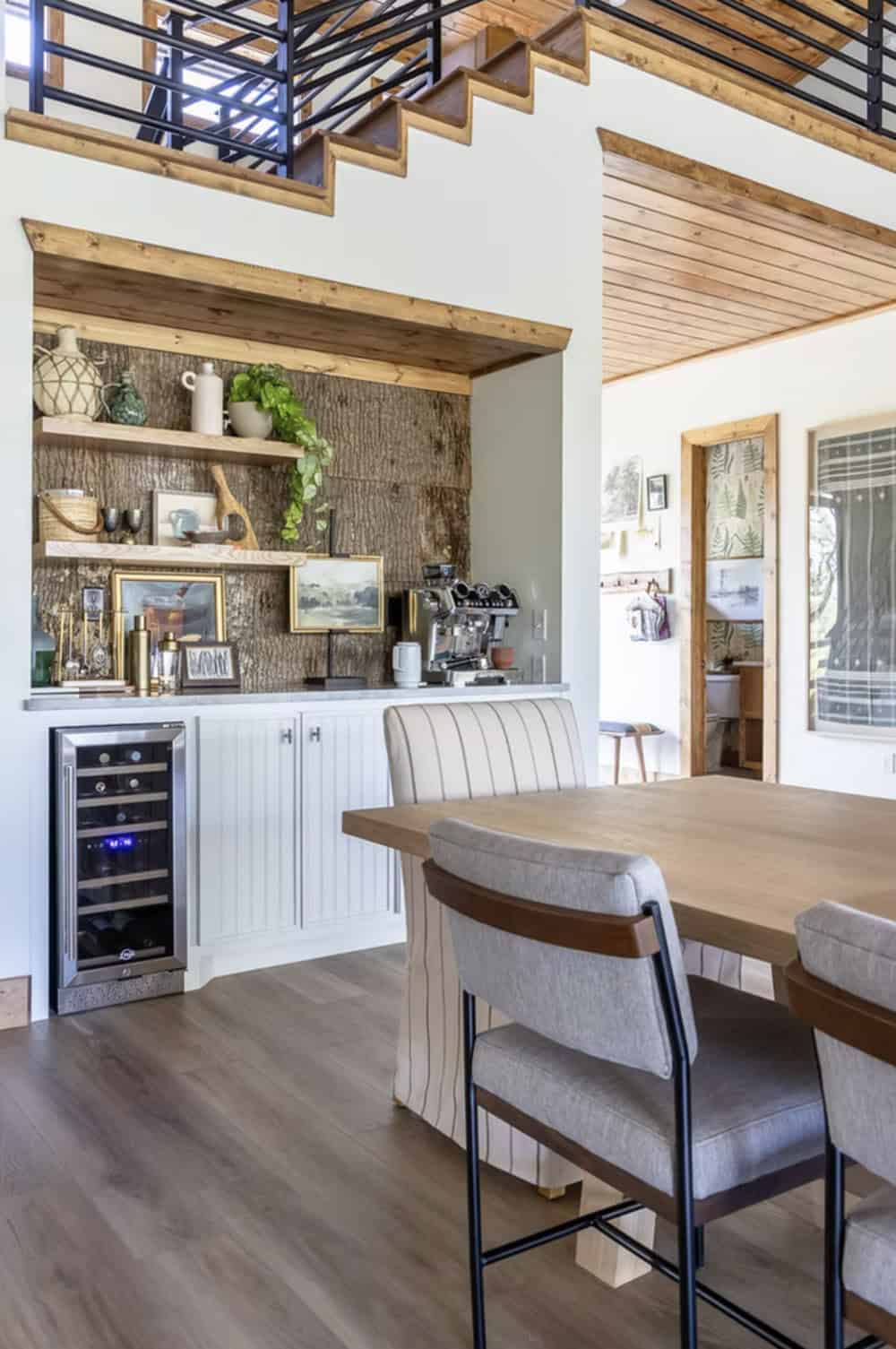 Coffee and bar niche with bark backsplash, open shelving, espresso machine, and wine fridge below