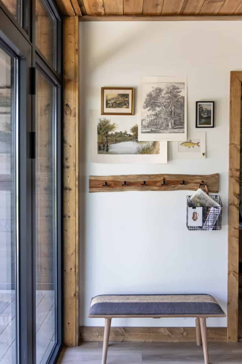 Entryway wall with nature-themed gallery art, live-edge coat rack, wire wall basket, and upholstered bench