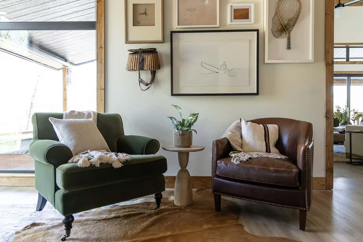 Bedroom corner with green velvet and brown leather armchairs, cowhide rug, and nature gallery wall
