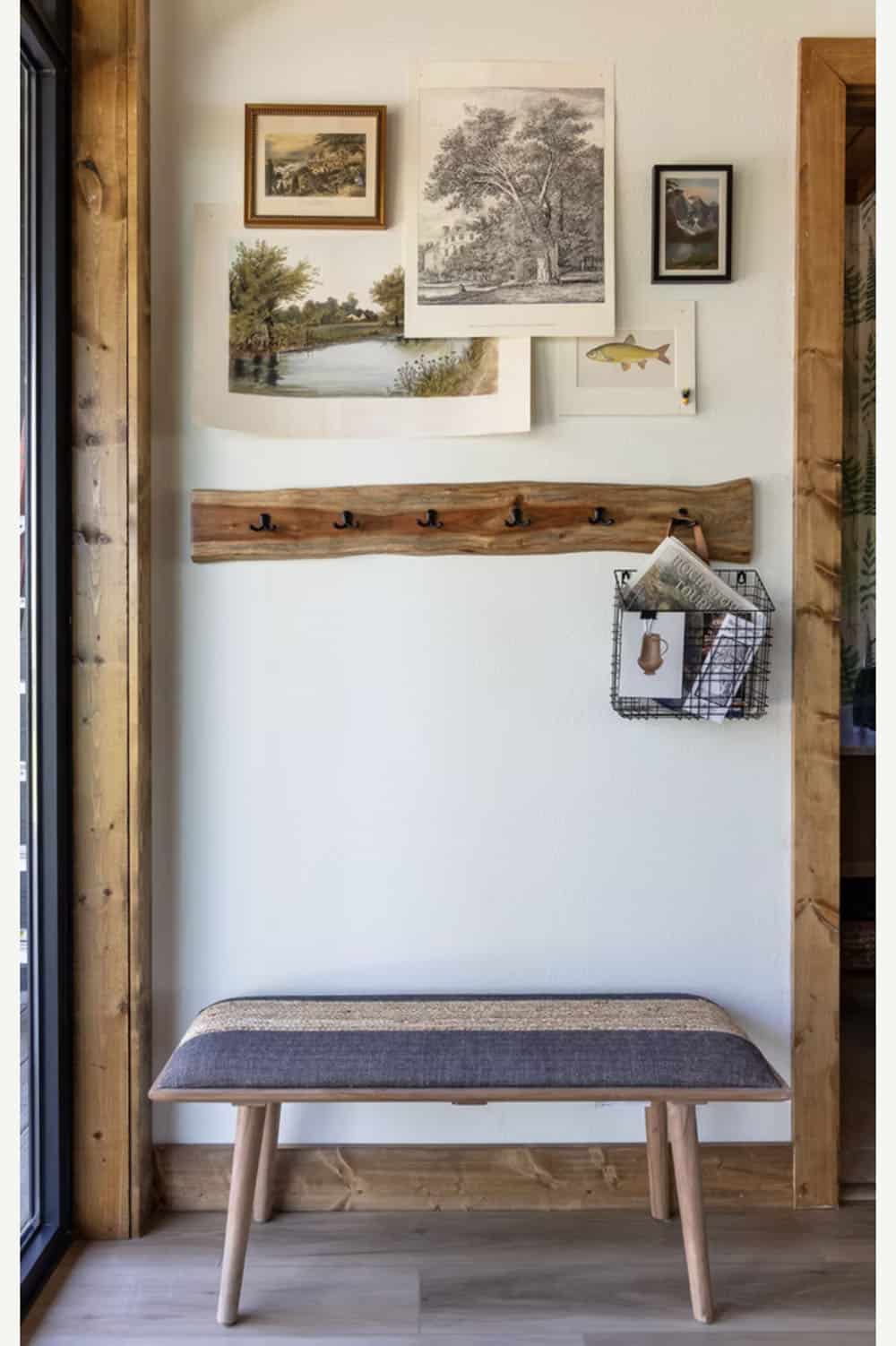 Entry mudroom wall with layered nature prints, live-edge coat rack, wire basket, and upholstered bench