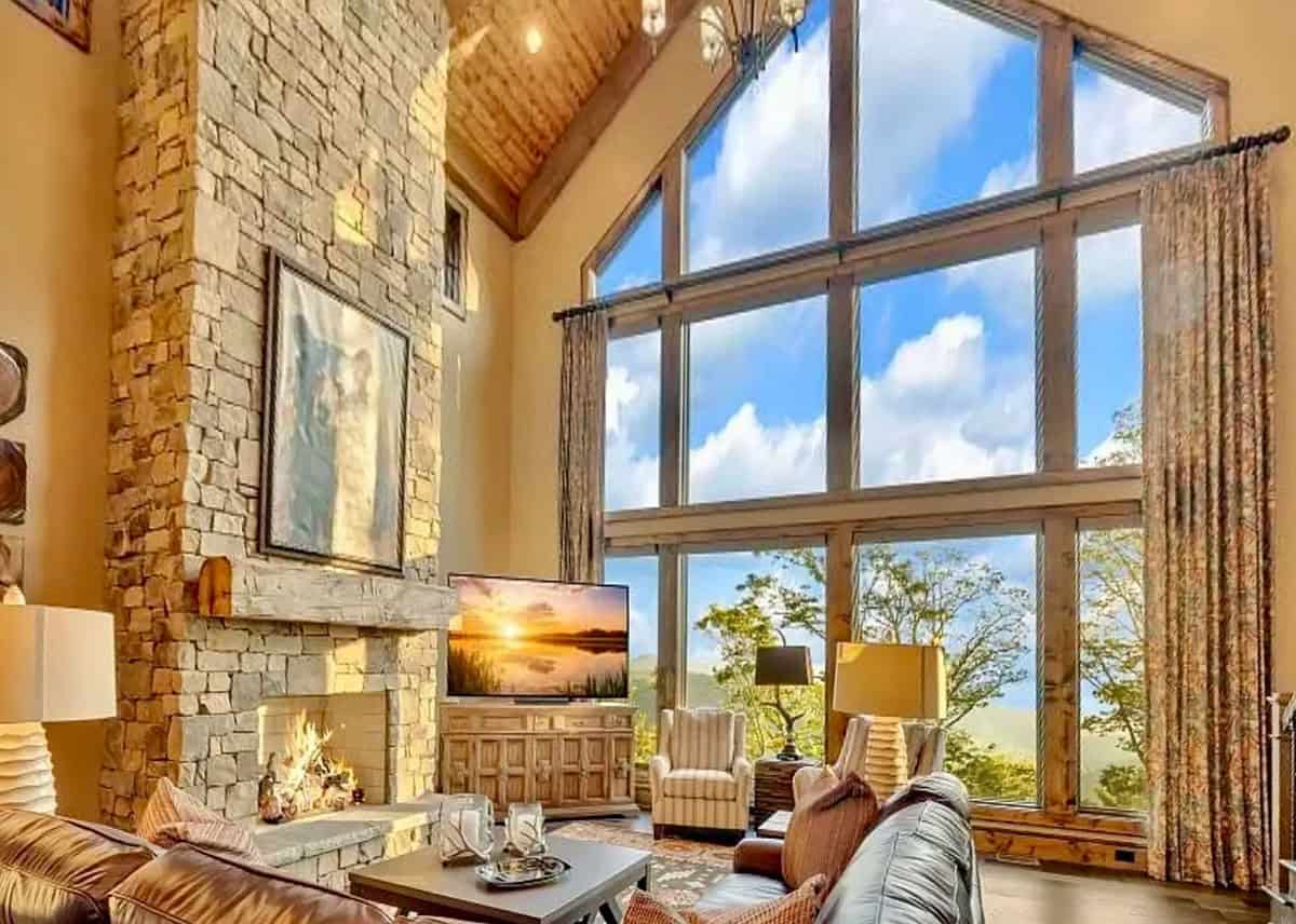 Soaring great room with floor-to-ceiling stone fireplace and panoramic mountain views