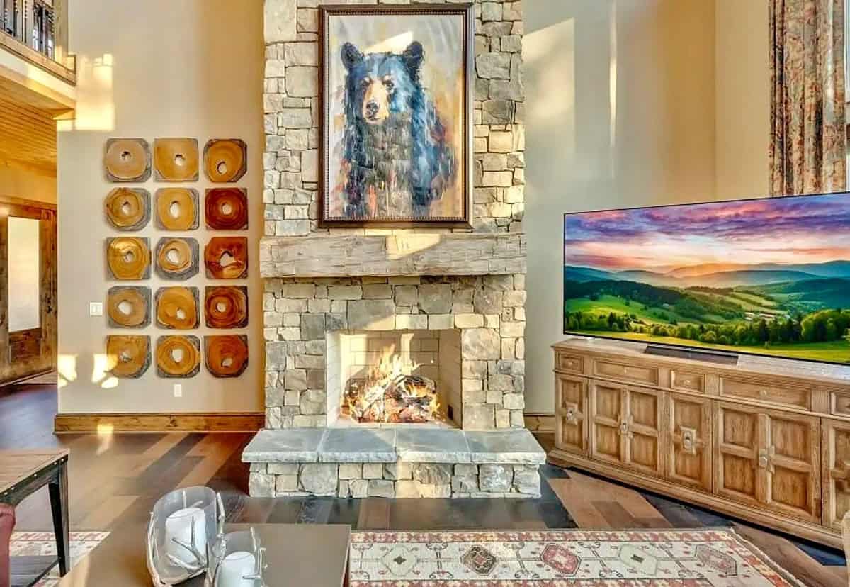 Stone fireplace with bear portrait painting and rustic wood-slice wall art