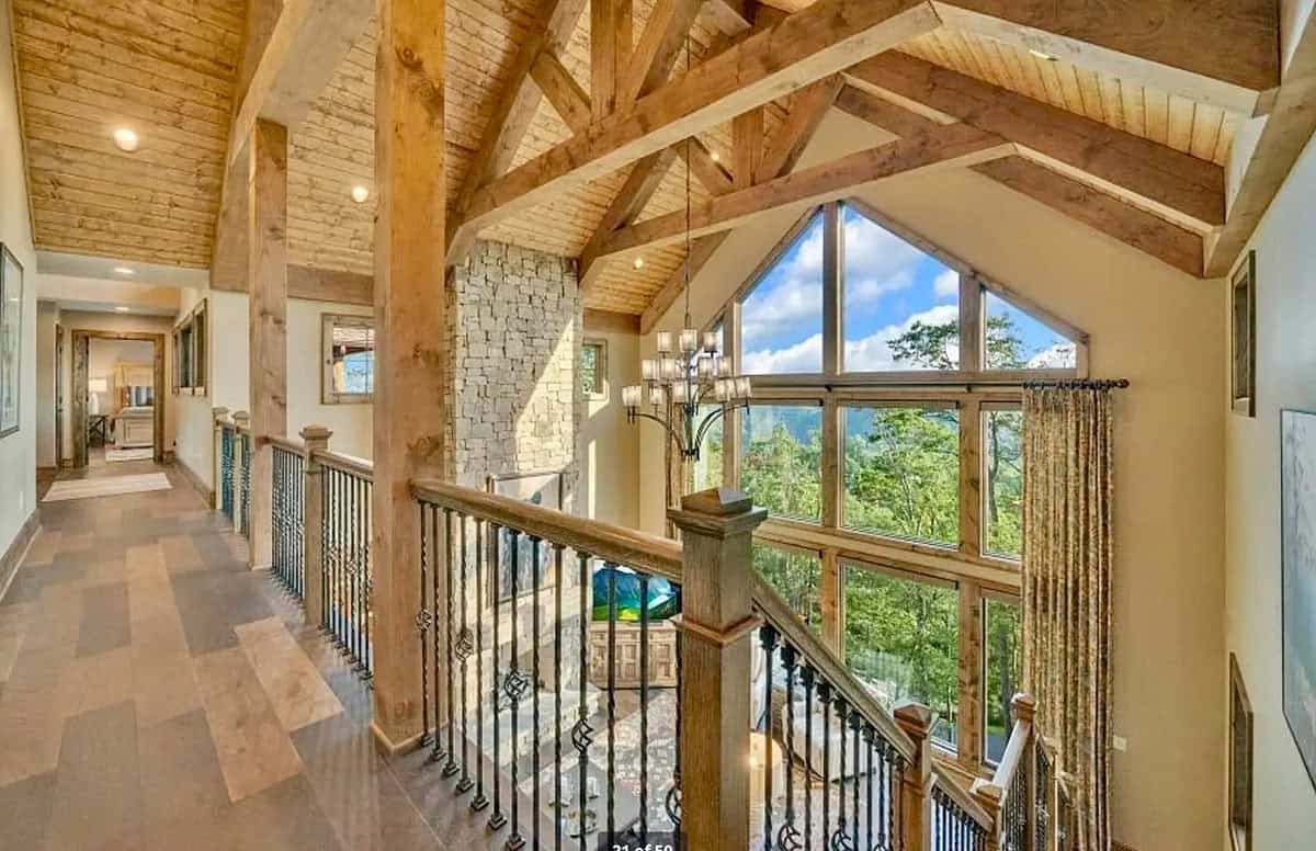Upper hallway with exposed timber trusses, wood ceiling, and mountain views