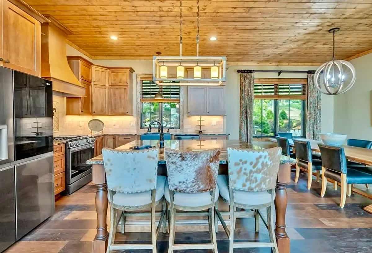 Kitchen and dining area with cowhide barstools, wood ceiling, and mountain views