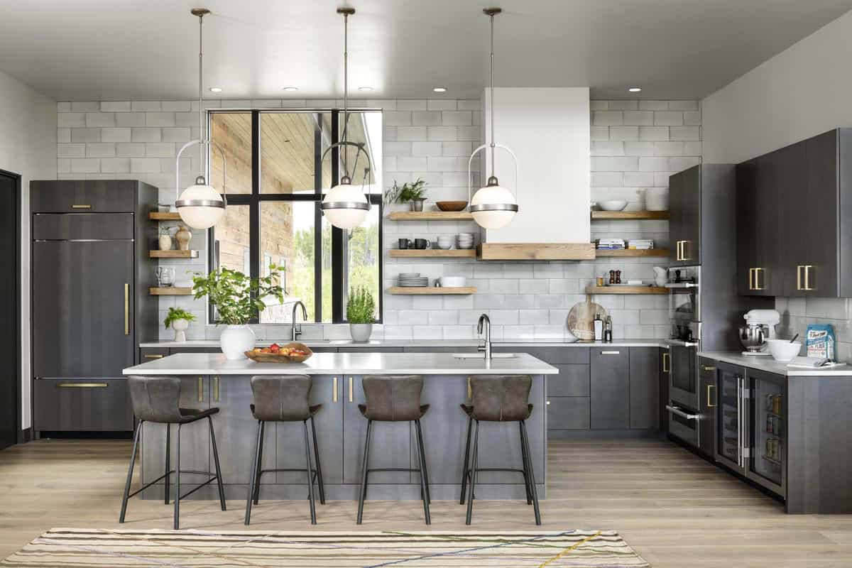 Dark gray kitchen with large island, open wood shelving, and globe pendant lights