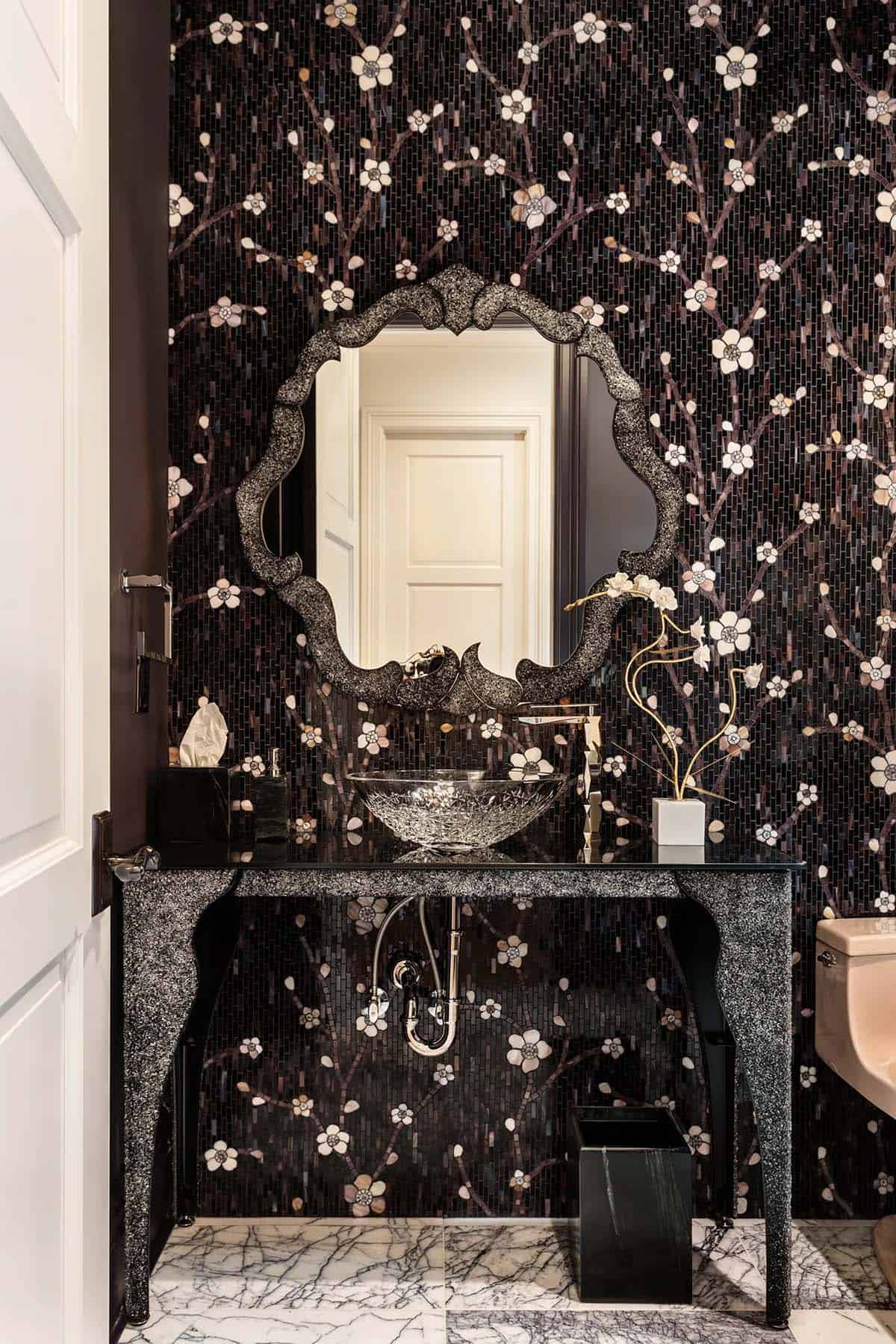 Dramatic powder room with black cherry blossom mosaic tile, crystal vessel sink, and ornate mirror